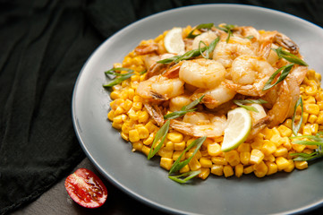 Grilled king prawns on dark plate