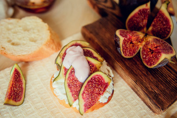 Fototapeta na wymiar Autumn dessert: bruschetta with ripe figs, soft cheese and honey on a light background.