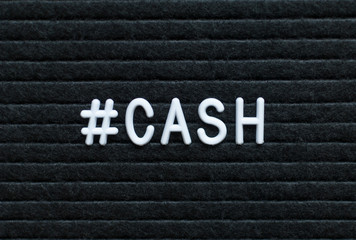 Hashtag word #cash written on the letter board. White letters on the black background.