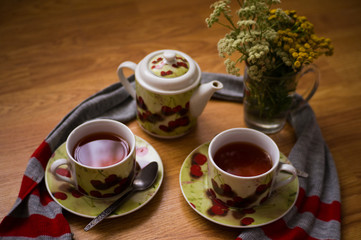 Tea ceremony, filled tea in service with wildflowers on the wood texture