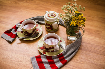 Tea ceremony, filled tea in service with wildflowers on the wood texture