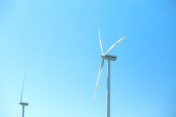 Electric wind mill turbines with blue sky background