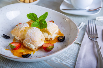 Close up view of beautiful elegant sweet dessert served on the plate. Beautiful decoration, restaurant dish, ready to eat. Tea time, cozy atmosphere.