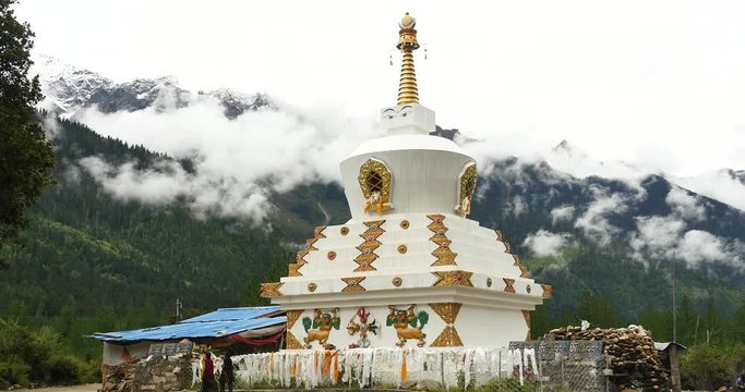 4k tibet people walking around buddhist white stupa in village,cloud cover mountain.