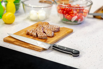 Sliced grilled marbled meat steak Filet Mignon, seasonings, fork, wooden cutting board. Juicy meat steak. Beef steak grilled fried. Side view. Roasted meat steak. Close-up.