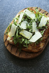 Homemade pizza with smoked meat and arugula