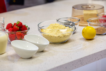 Ingredients for cooking strawberry pie or cake on white background. Side view. Flour, milk, sugar, strawberry, lemon. Bakery background. Recipe for strawberry pie.