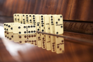 Dominoes board game stands on a wooden background. An interesting board game for the whole family