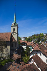 View of Holy Spirit Church (Heiliggeistkirche) with rooftops of houses in Bern Switzerland