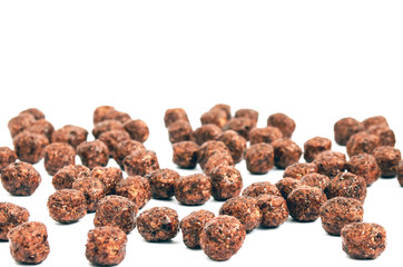 Chocolate balls corn flakes isolated with copy space background. Cereals texture. Side view. Corn Chocolate Flakes Isolated On White Background.