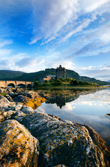 Fototapeta na wymiar Tourists favourite place in Scotland - Isle of Skye. Very famous castle in Scotland called Eilean Donan castle. Top of the mountains.Scottish Highlands. Castle with reflection in the lake.