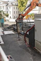 Bagger meiselt strasse auf