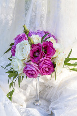flower arrangement of white and pink roses in a glass, wedding decoration on a light background