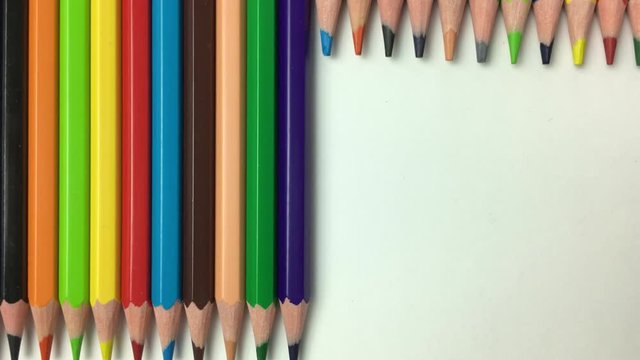 Lapices de colores se deslizan hacia arriba, dejando un fondo blanco.