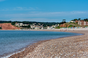 Pebble Beach  and coastal properties at Budleigh Salterton, Devon on bright sunny day, showing triassic red sandstone cliffs