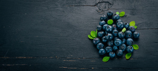 Fresh berries of blueberries. On a wooden background. Top view. Free space for your text.