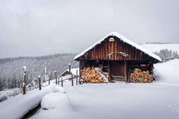 Fantastic winter landscape with wooden house in snowy mountains. Christmas holiday concept. Carpathians mountain, Ukraine, Europe