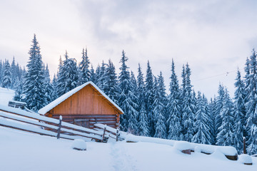 Fantastic winter landscape with wooden house in snowy mountains. Christmas holiday concept. Carpathians mountain, Ukraine, Europe