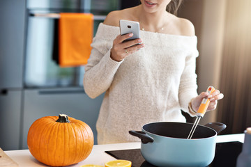 Adult woman in the kitchen preparing pumpkin dishes for Halloween