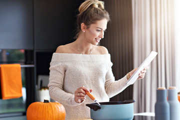 Adult woman in the kitchen preparing pumpkin dishes for Halloween