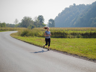 Obraz premium woman jogging along a country road