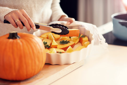 Adult woman in the kitchen preparing pumpkin dishes for Halloween