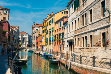 Traditional canal street with boats in Venice, Italy.