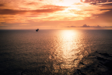 Sunset at the sea with a ship in distant plane
