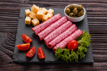 delicious sliced salami on a stone plate wooden background