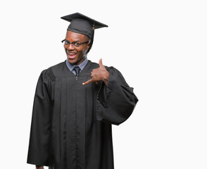 Young graduated african american man over isolated background smiling doing phone gesture with hand and fingers like talking on the telephone. Communicating concepts.