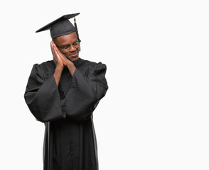 Young graduated african american man over isolated background sleeping tired dreaming and posing with hands together while smiling with closed eyes.