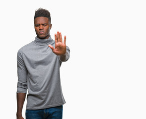 Young african american man over isolated background doing stop sing with palm of the hand. Warning expression with negative and serious gesture on the face.