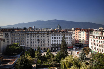 Obraz premium Aerial view of East European City. Many buildings with a mountain background. Urban sprawl. Rila hotel view. Bulgaria, Sofia - September 1, 2018