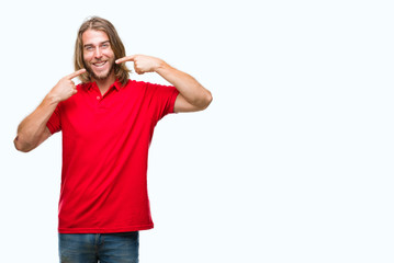 Fototapeta premium Young handsome man with long hair over isolated background smiling confident showing and pointing with fingers teeth and mouth. Health concept.