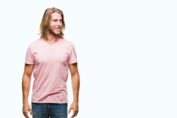Obraz premium Young handsome man with long hair over isolated background looking away to side with smile on face, natural expression. Laughing confident.