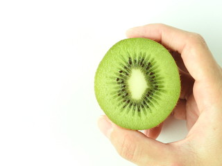 Top view of one hand holding a sliced ripe fresh kiwifruits on white background. Kiwi has fibrous, flesh and edible black seeds.Fruit, nature, health and nutrition concept. Summer food. Copy space.