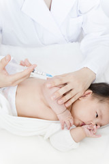 Fototapeta na wymiar 医師(看護師)により腕に注射を打たれ泣いている新生児の赤ちゃん。予防接種、インフルエンザ、病気、治療イメージ