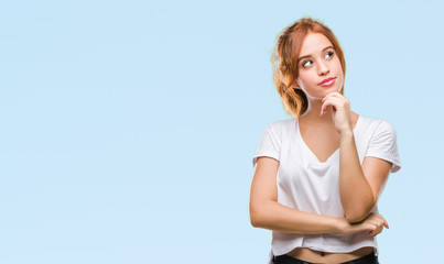 Fototapeta premium Young beautiful woman over isolated background with hand on chin thinking about question, pensive expression. Smiling with thoughtful face. Doubt concept.