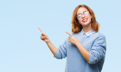 Young beautiful woman over isolated background wearing winter sweater smiling and looking at the camera pointing with two hands and fingers to the side.