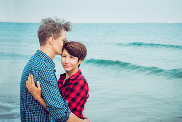 Portraits of happy romantic couple on the sea beach embracing each other. Concept of lovers happy moments on holiday, vacation. Boyfriend and girlfriend having date. Selective focus. Copy space.