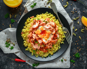 Traditional Indian-English kedgeree breakfast: basmati rice with egg benedict and hot smoked sweet chilli salmon.