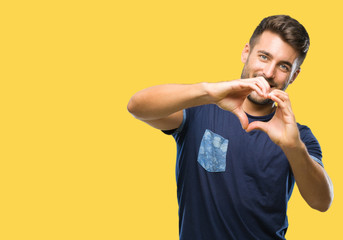 Young handsome man over isolated background smiling in love showing heart symbol and shape with hands. Romantic concept.