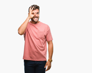 Fototapeta premium Young handsome man over isolated background doing ok gesture with hand smiling, eye looking through fingers with happy face.