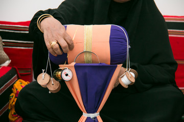 Hands of Emiraty woman who is making traditional embroidery talli