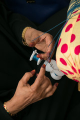 Hands of Emiraty woman who is making traditional embroidery talli