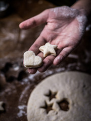 pastry chef hand use cutting mold to cut Cookie dough on kitchen table.