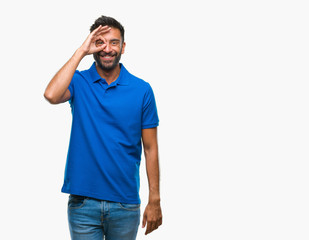 Fototapeta premium Adult hispanic man over isolated background doing ok gesture with hand smiling, eye looking through fingers with happy face.