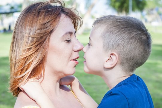 Young and beautiful Caucasian woman looking at her son, face to face close up portrait, mother child love family concept. Look at each other. Single mother.