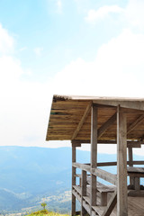 Picturesque landscape with wooden gazebo and mountain forest on background