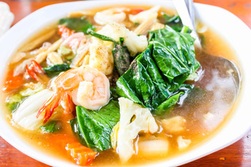 Closeup of Fried noodle with seafood and broccoli on white dish